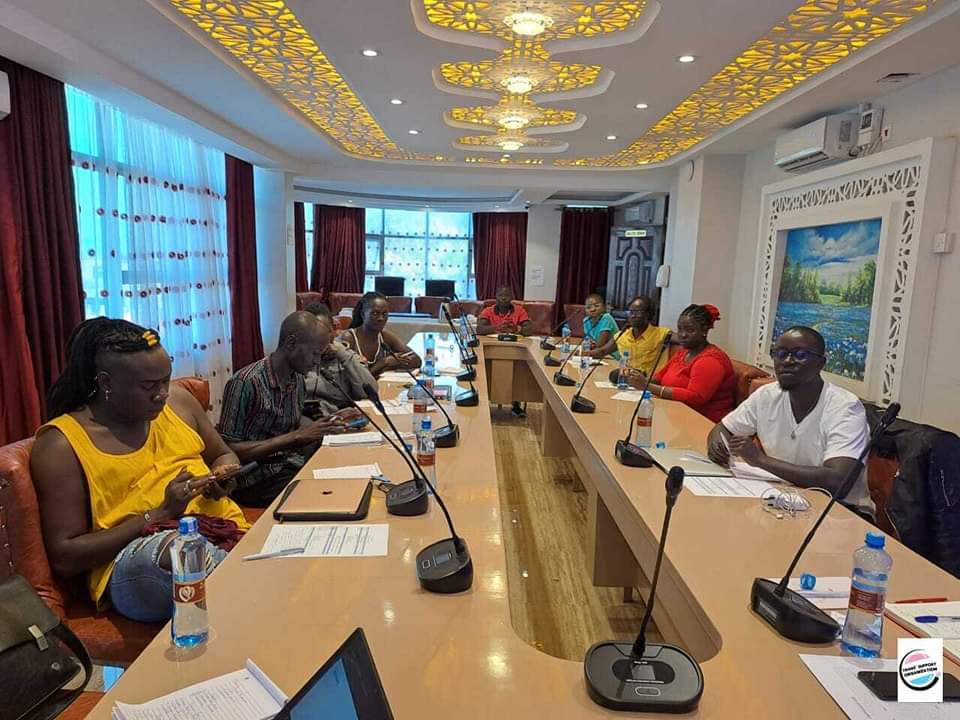 a group of adults gather around a conference table